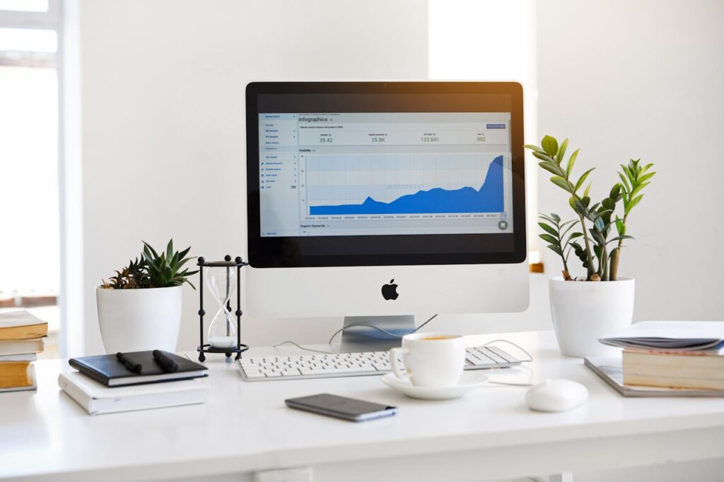 zipwp-image-572056 A clean, contemporary workspace featuring a desktop with analytics on the screen and plants for a fresh look.