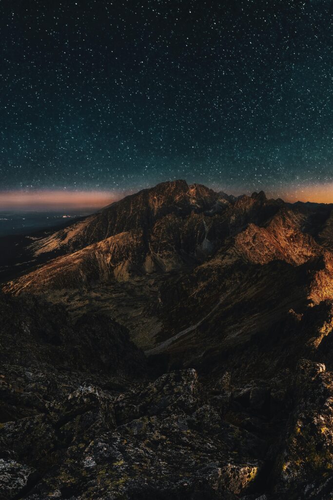 Stunning starry night sky over rugged mountains, perfect for nature lovers.