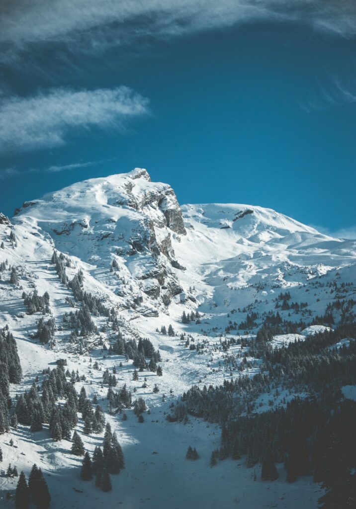 Stunning view of snow-covered mountain peaks against a deep blue sky, capturing winter's beauty.